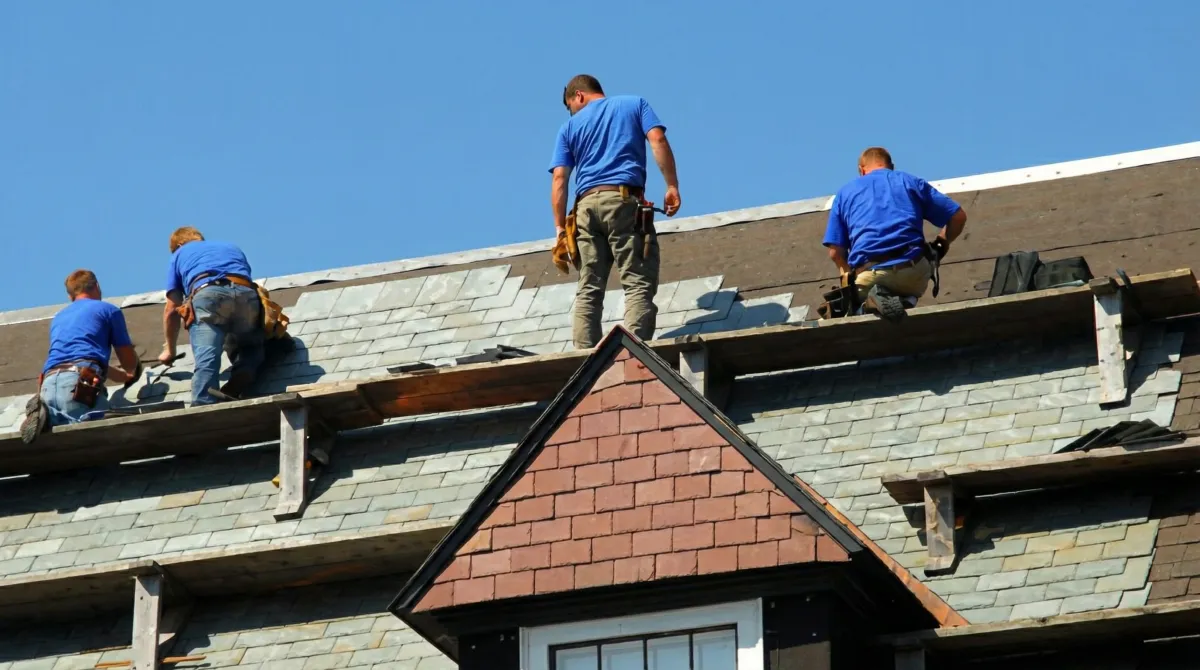 Roof replacement in progress with a team of professional contractors installing new shingles on a residential home in Denver, CO